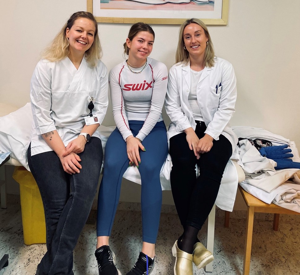 3 damer som sitter på en undersøkelsesbenk, foto